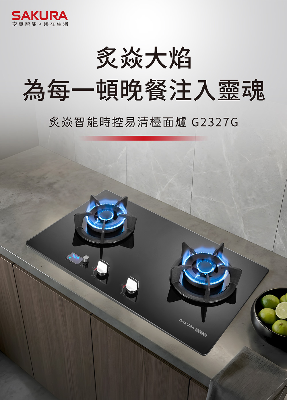 Sakura two-burner gas stovetop (model G2327G) on a gray countertop with blue flames; brand logo top-left and Chinese promotional text on the wall, plus a bowl of limes nearby.